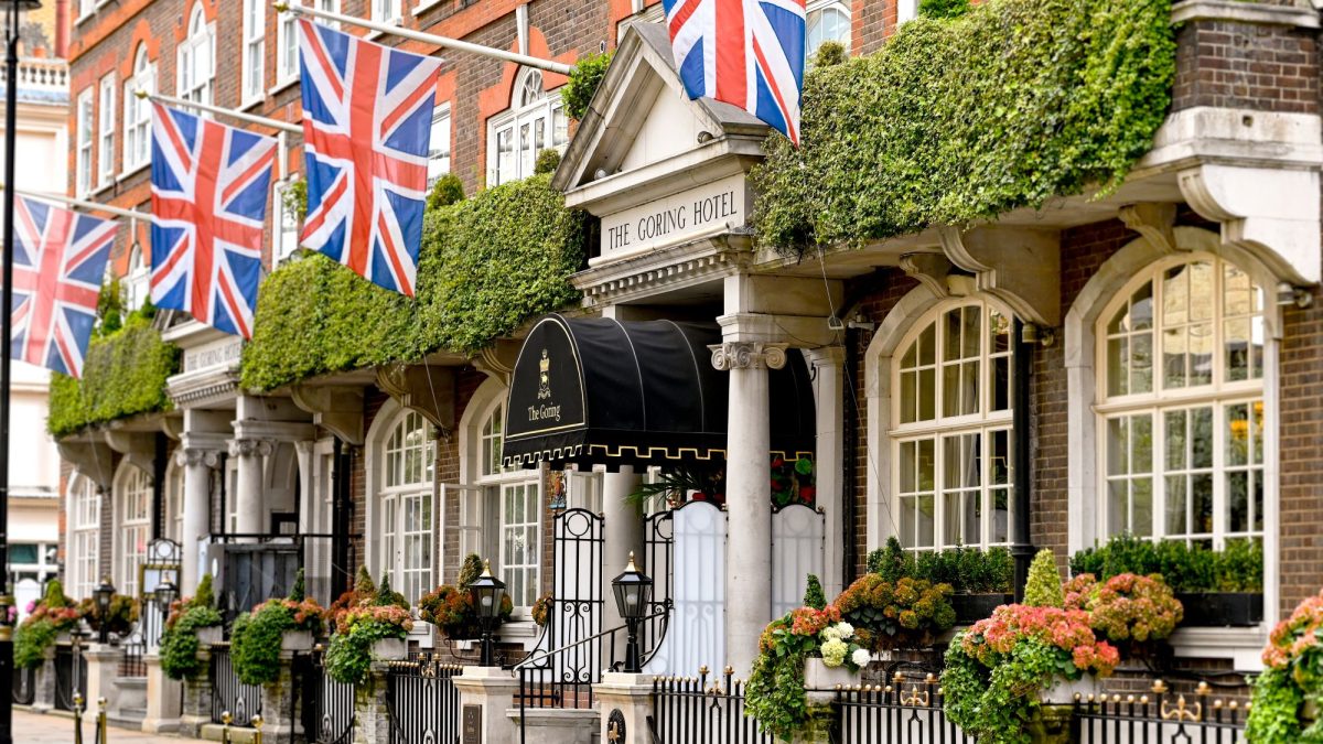The Goring Hotel entrance adorned with British flags and lush greenery, showcasing London’s festive charm.