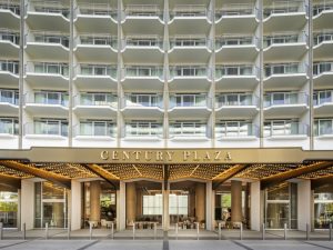Entrance of the Hyatt Regency Century Plaza featuring a modern façade and outdoor seating area.