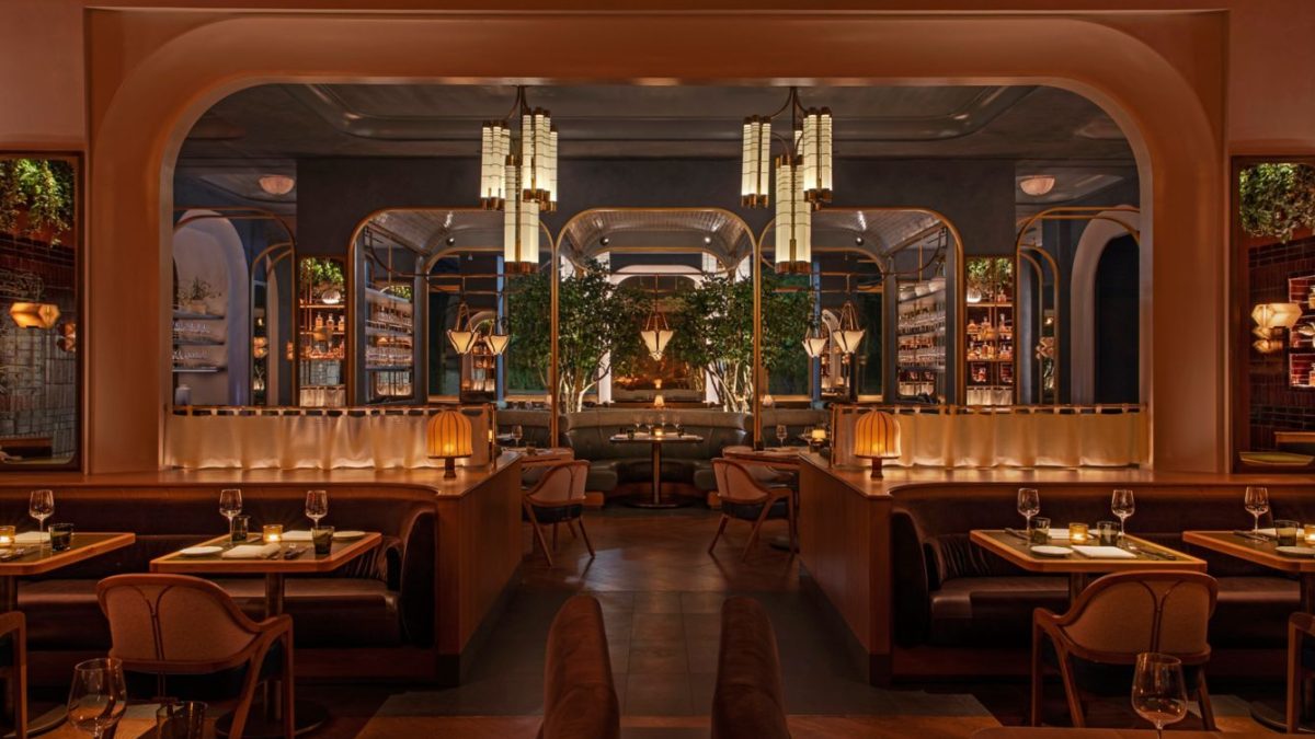 Elegant interior of Bourbon Steak New York featuring plush seating, ambient lighting, and lush greenery.