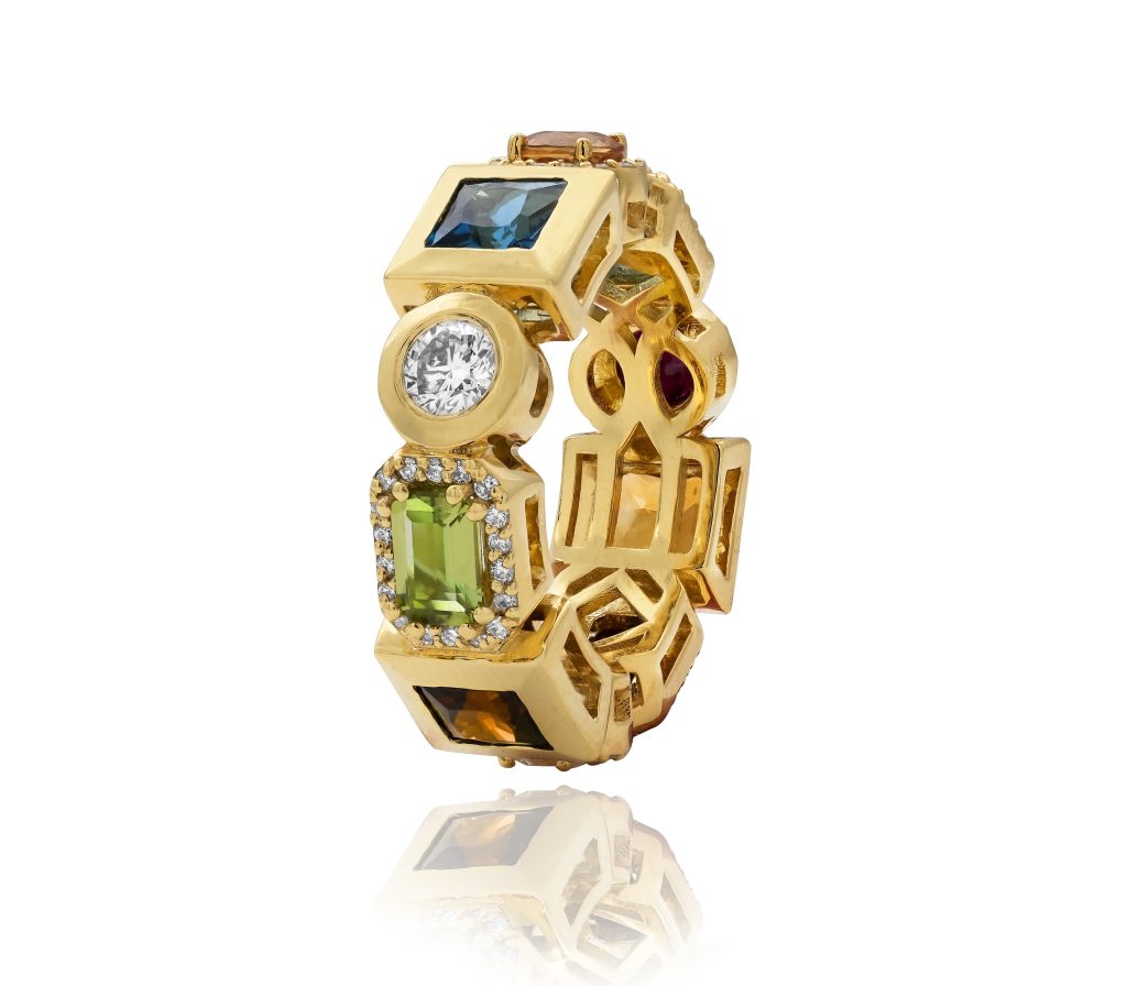 Gold ring featuring a variety of colorful gemstones, including a large diamond, showcasing high-jewelry elegance.