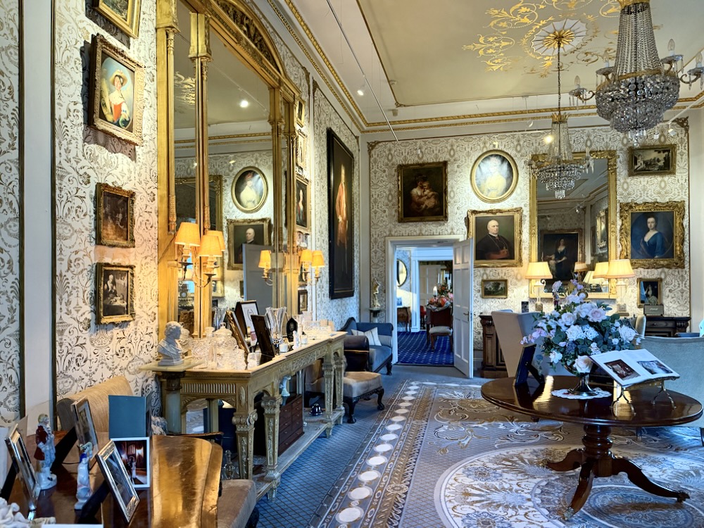 Elegant interior of Cabra Castle showcasing ornate decor, vintage portraits, and a beautifully arranged floral centerpiece.