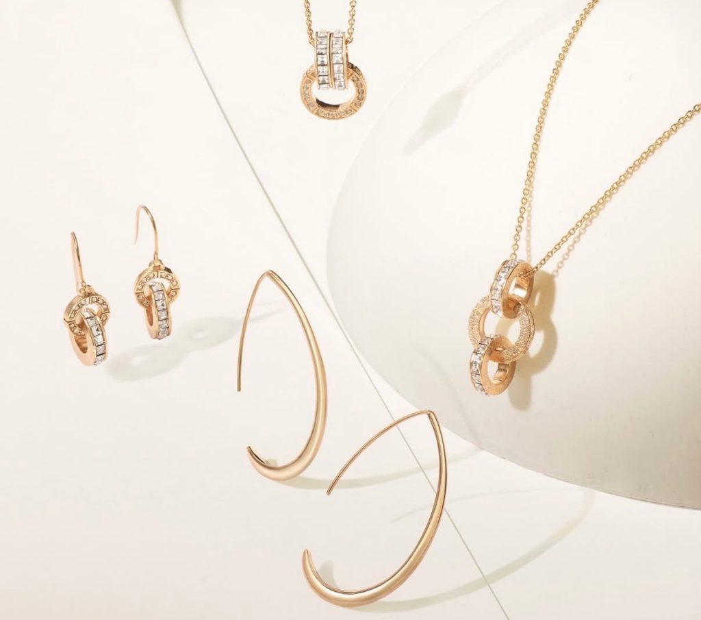 Gold earrings and necklace featuring sparkling details, displayed elegantly on a soft background. Perfect for special occasions.