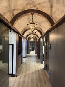 Elegant hallway of Dr. Tyler Hales' speakeasy-inspired aesthetic practice, featuring arched ceilings and stylish lighting fixtures.