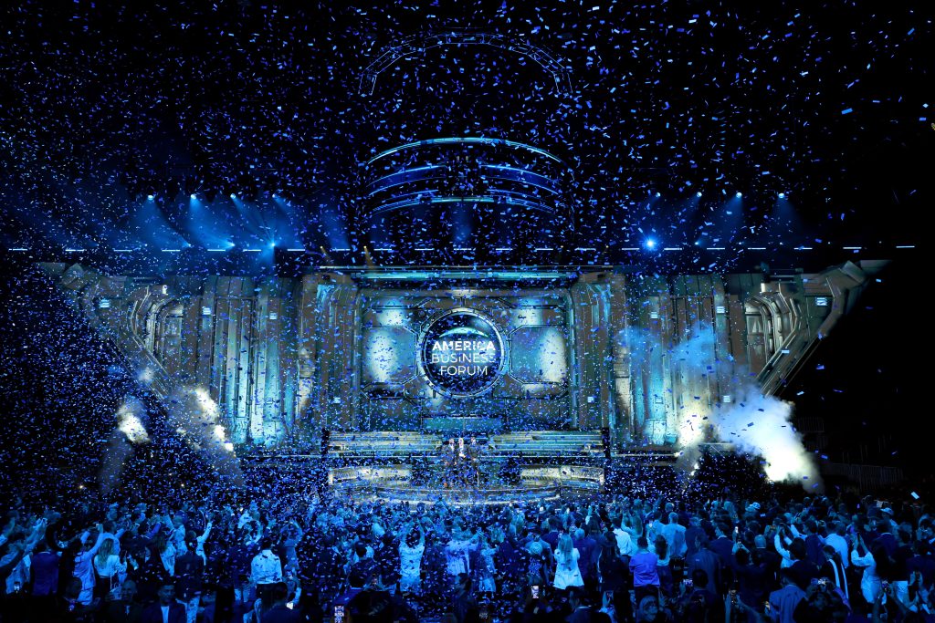 Confetti falls over a lively crowd during the inaugural America Business Forum event in Miami, celebrating various industry leaders.