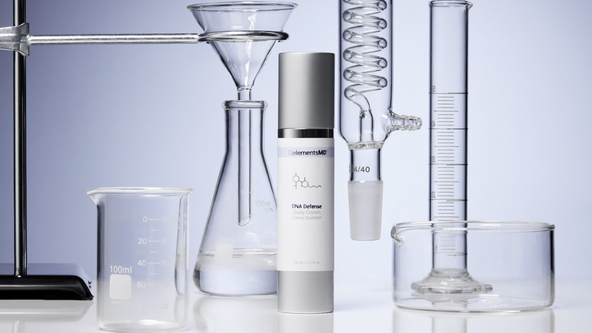CielementsMD DNA Defense daily cream surrounded by laboratory glassware, emphasizing skincare science for UVA protection.