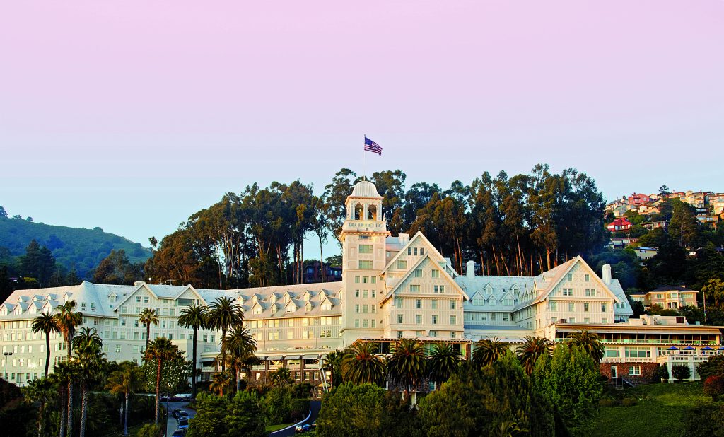 Historic hotel exterior at sunset, surrounded by palm trees and hillside, ideal for Super Bowl LX accommodations.