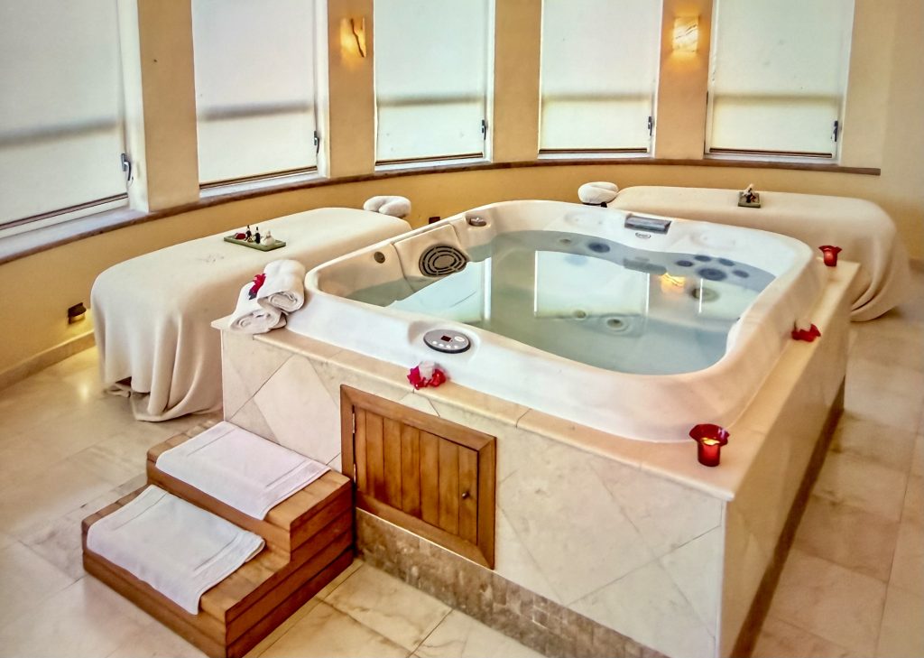 Relaxing spa room featuring a jacuzzi, massage tables, and candlelight for a serene atmosphere at Villa del Arco in Cabo.