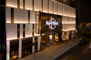 Hard Rock Hotel New York entrance at night, featuring illuminated signage and a modern architectural design.