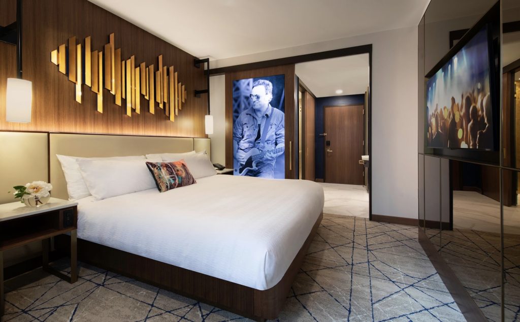 Stylish hotel room at Hard Rock Hotel New York featuring a modern design, a large bed, and artwork, ideal for Fashion Week.