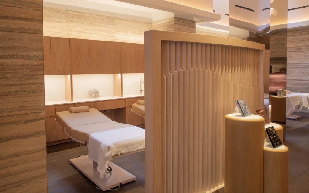 Spa treatment room with wooden partitions and massage tables, featuring a serene atmosphere for winter beauty rituals.