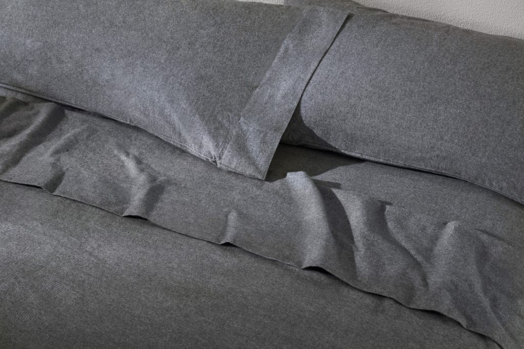 Soft gray bedding with a textured finish, perfect for creating a cozy and romantic atmosphere.