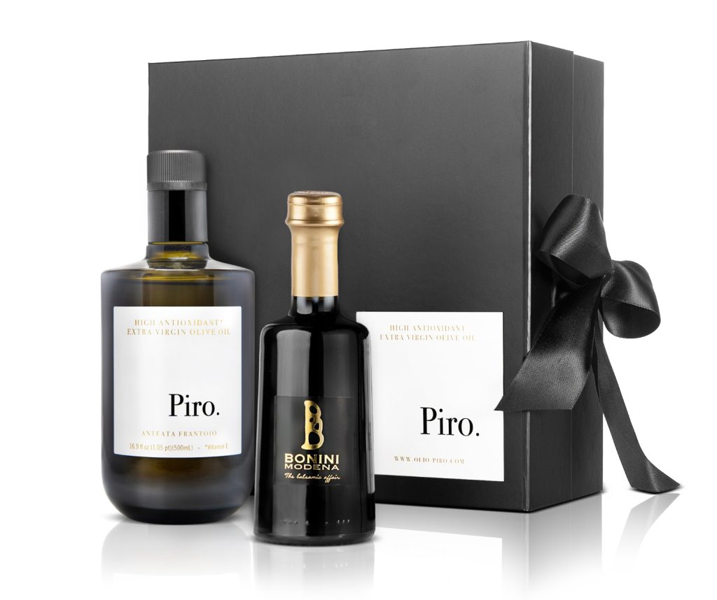 Two bottles of premium olive oil presented in a stylish black gift box, adorned with a black ribbon.