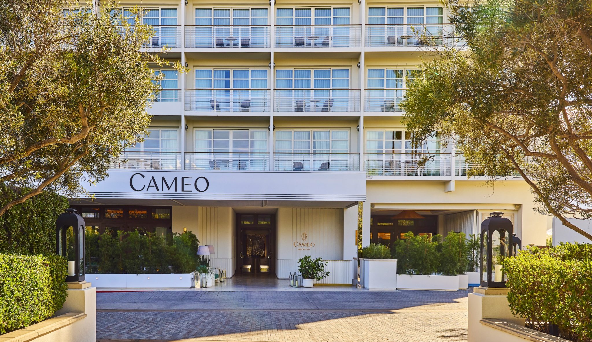 Cameo Beverly Hills entrance featuring stylish architecture, greenery, and the hotel's name prominently displayed.