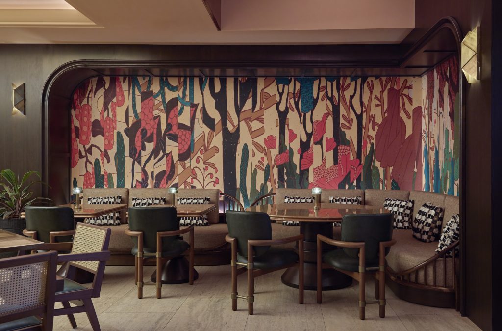 Stylish seating area featuring colorful wallpaper and plush cushions, perfect for relaxing in the Cameo Beverly Hills.