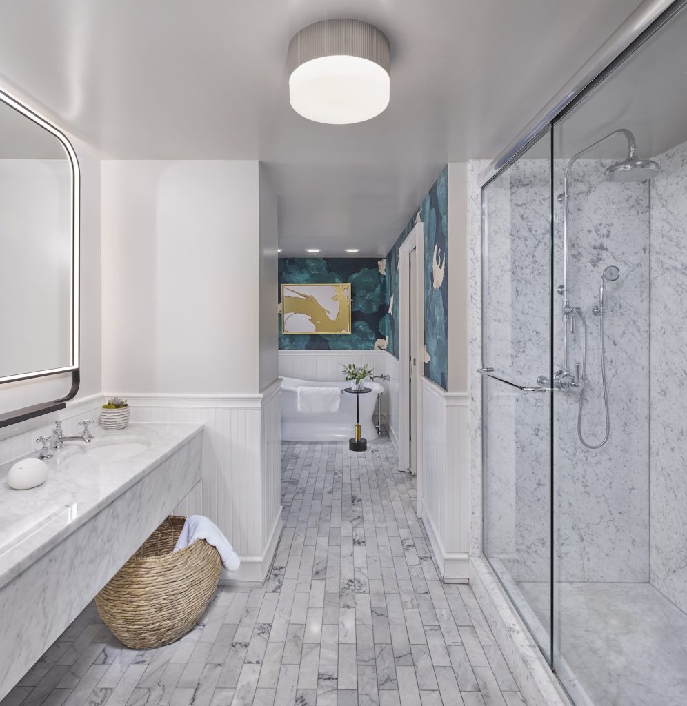 Modern bathroom featuring a marble vanity, walk-in shower, freestanding bathtub, and stylish decor in soothing colors.