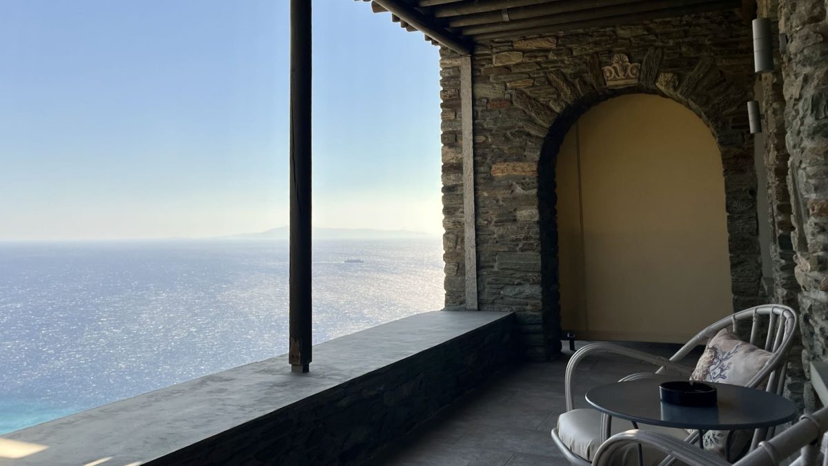 Balcony view of the Aegean Sea from the Aegean Castle hotel, showcasing a serene spot with comfortable seating.