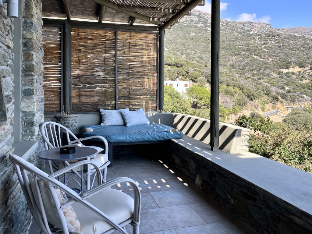 Cozy outdoor seating area with a view, featuring comfortable chairs and cushions at Aegean Castle on Andros Island.