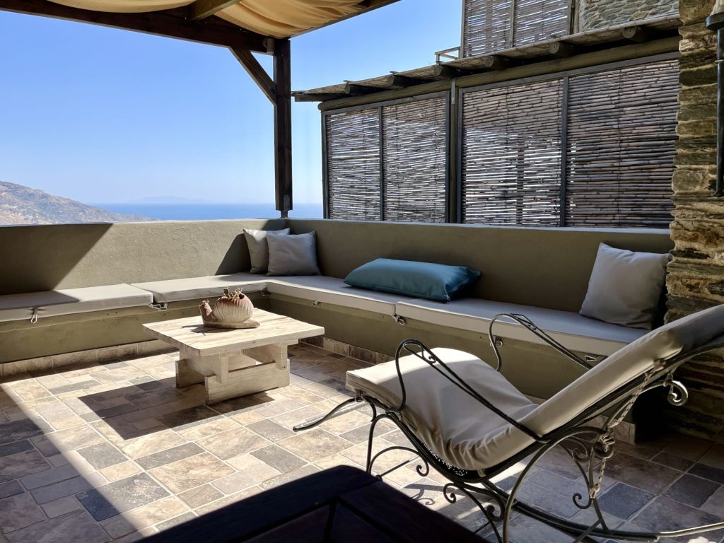 Cozy outdoor seating area with ocean views, featuring a stone table and decorative elements at Aegean Castle Hotel.