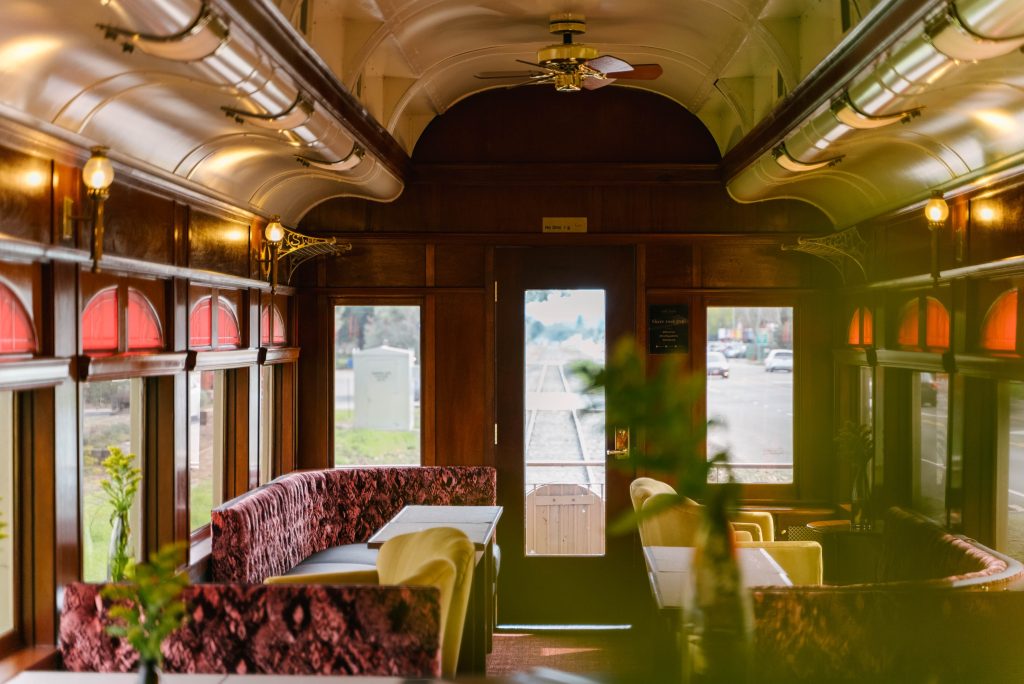 Interior view of a vintage train car with plush seating and large windows, highlighting a cozy atmosphere in Napa Valley.