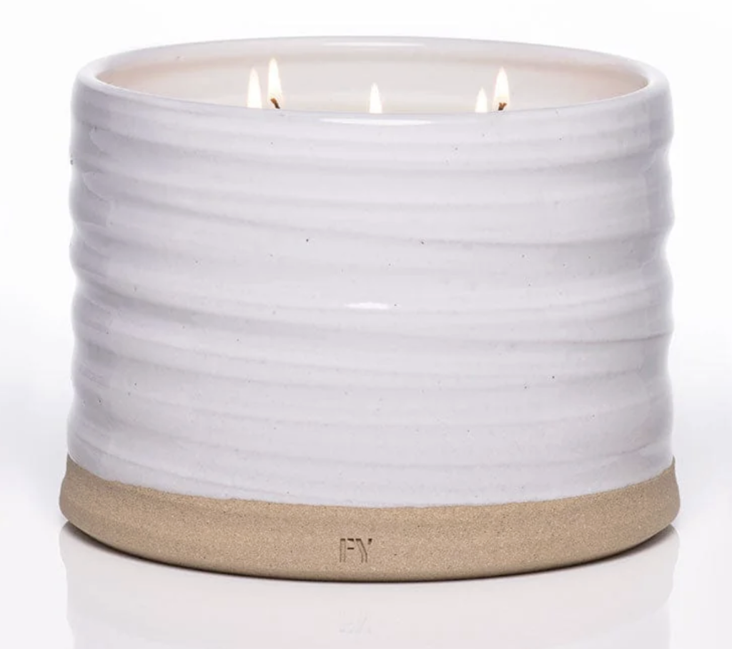 Three-wick scented candle in a white ceramic vessel with a ribbed design and a natural clay base. Perfect for gifting.