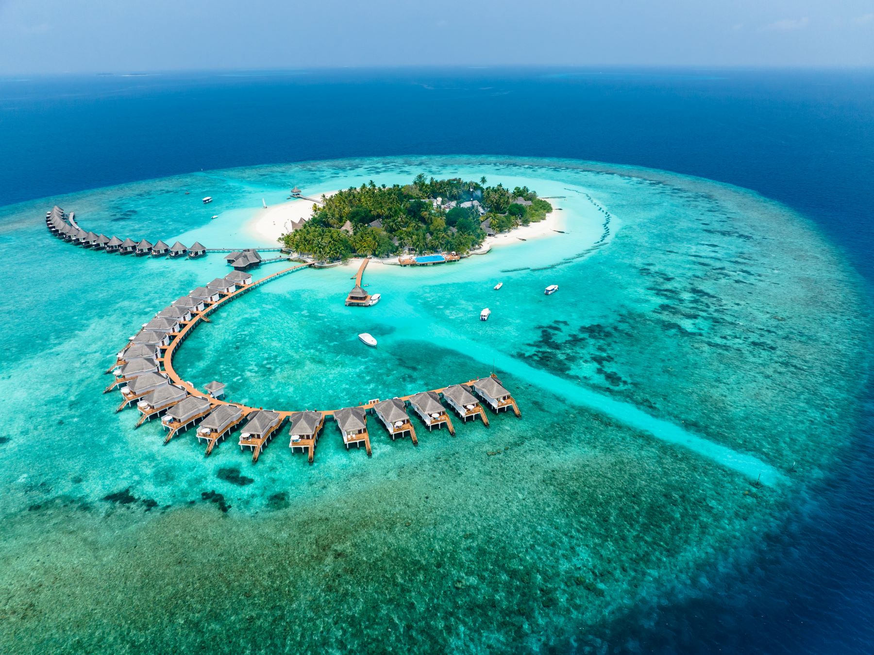 Luxury overwater bungalows surrounded by turquoise waters at a tropical Maldives island retreat.