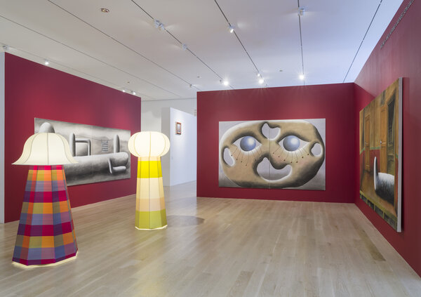 Colorful lamps and contemporary art pieces displayed in a modern gallery with red walls at Art Basel Miami Beach 2025.