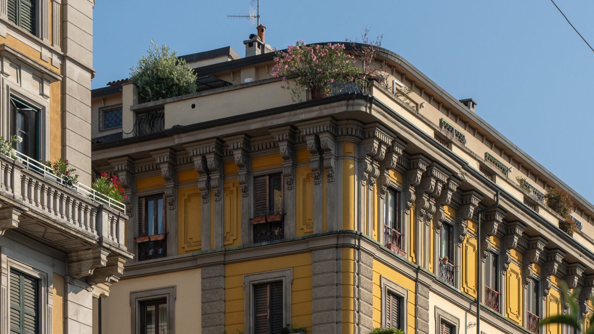 Historic building with ornate architecture and greenery on the rooftops, highlighting the design of Hotel Milu Milano.