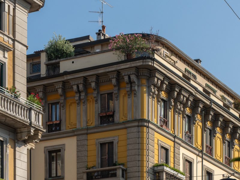 Historic building with ornate architecture and greenery on the rooftops, highlighting the design of Hotel Milu Milano.