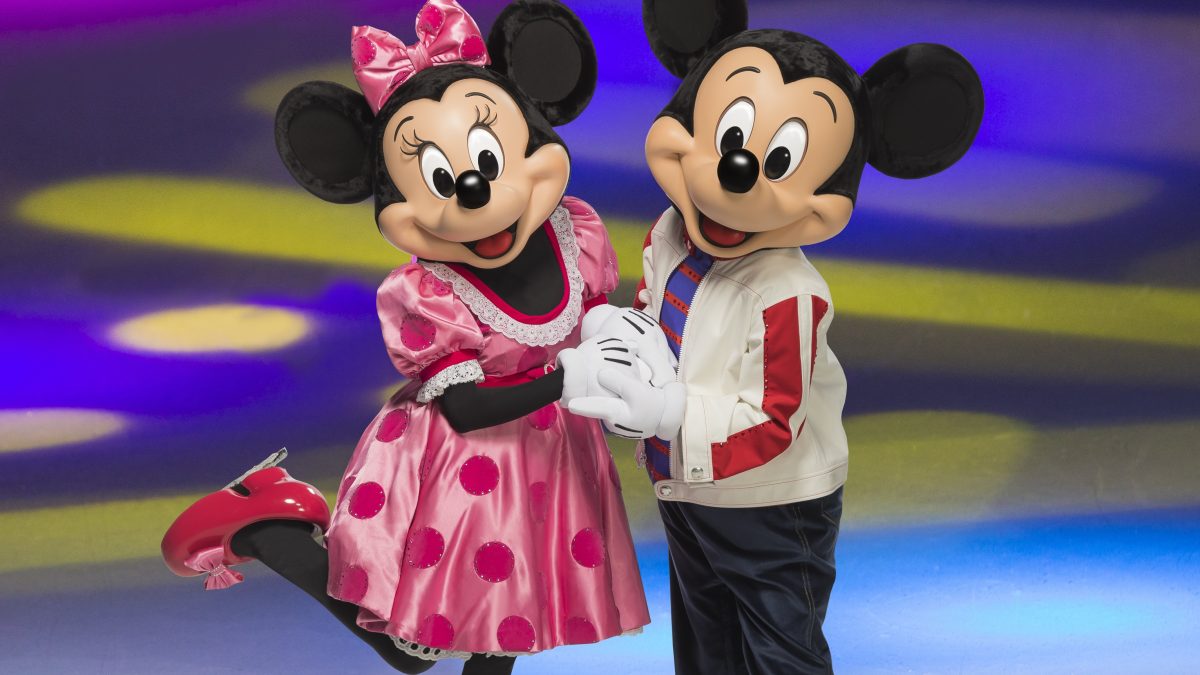 Minnie and Mickey Mouse skating together on ice, dressed in colorful outfits against a vibrant, colorful background.