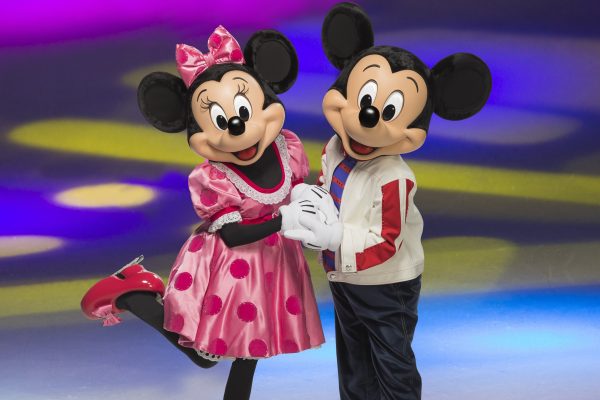 Minnie and Mickey Mouse skating together on ice, dressed in colorful outfits against a vibrant, colorful background.