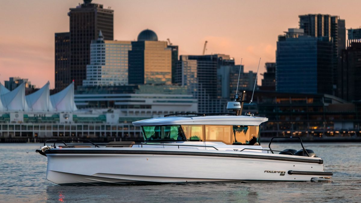 Axopar 37 XC boat cruising in front of a city skyline at sunset, showcasing modern design and luxury yachting.