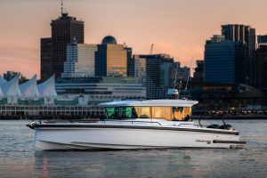 Axopar 37 XC boat cruising in front of a city skyline at sunset, showcasing modern design and luxury yachting.