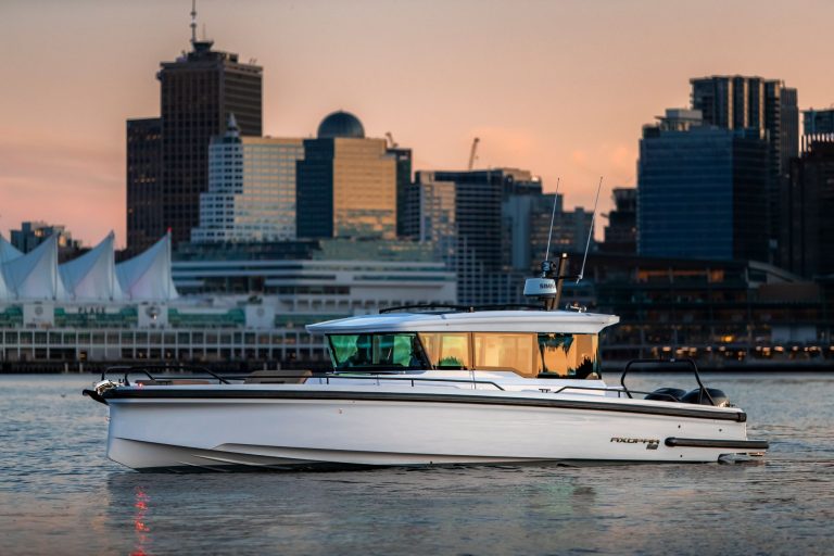 Axopar 37 XC boat cruising in front of a city skyline at sunset, showcasing modern design and luxury yachting.