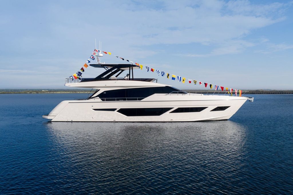 A luxurious yacht with decorative flags cruising in calm waters under a clear sky.
