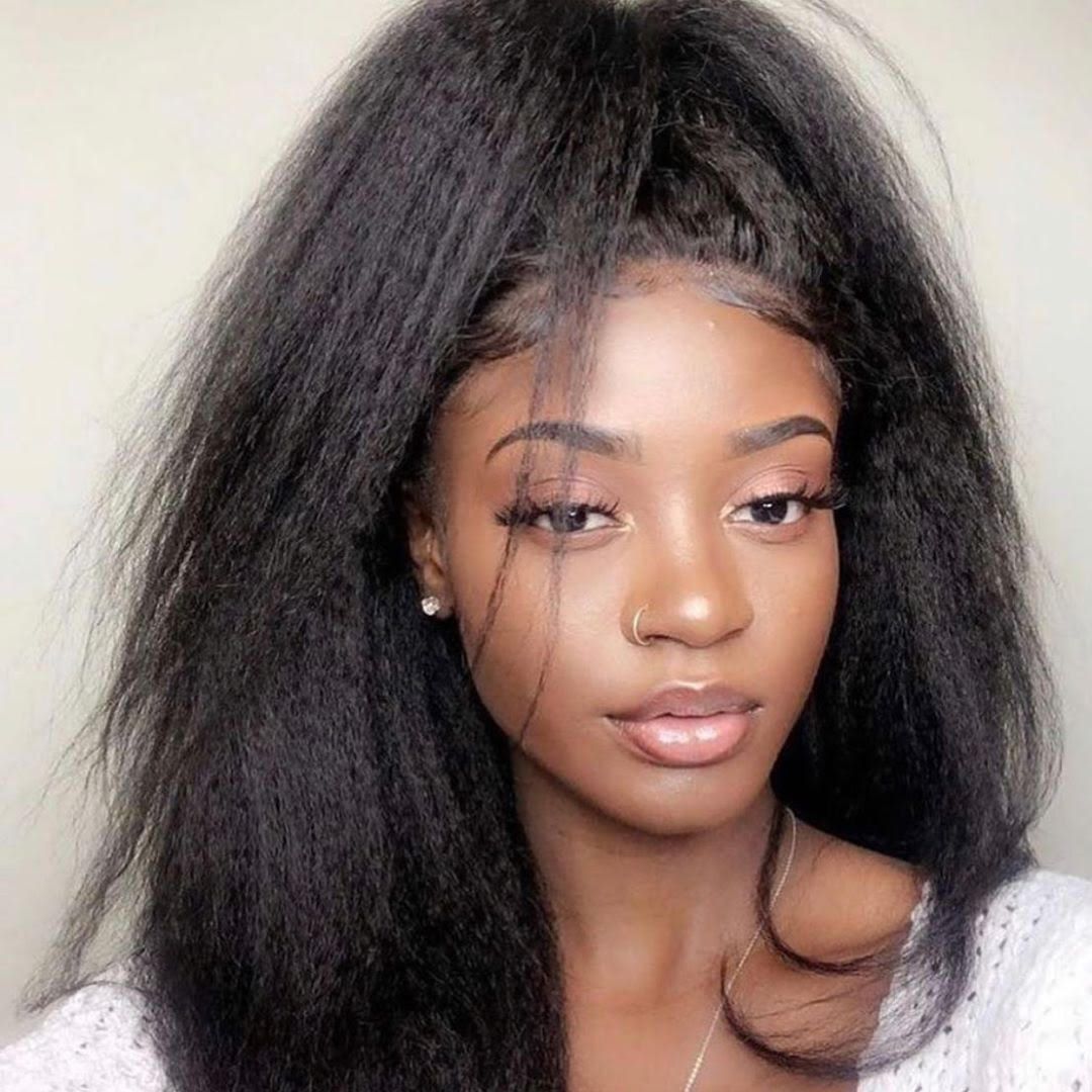 Woman with long, kinky straight hair styled in a half-updo, showcasing the texture and volume of Nadula hair bundles.