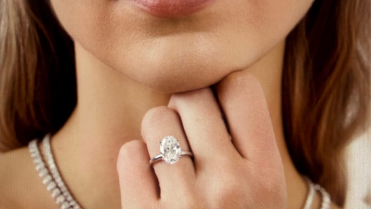 A close-up of a person wearing an engagement ring and elegant jewelry, showcasing trends in personalized engagement rings.