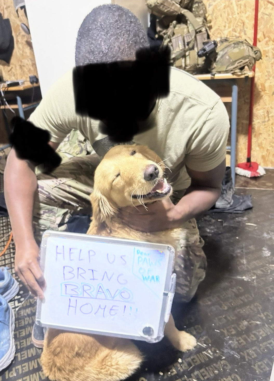 Soldier holding a smiling dog, with a sign asking for help to bring the dog named Bravo home.