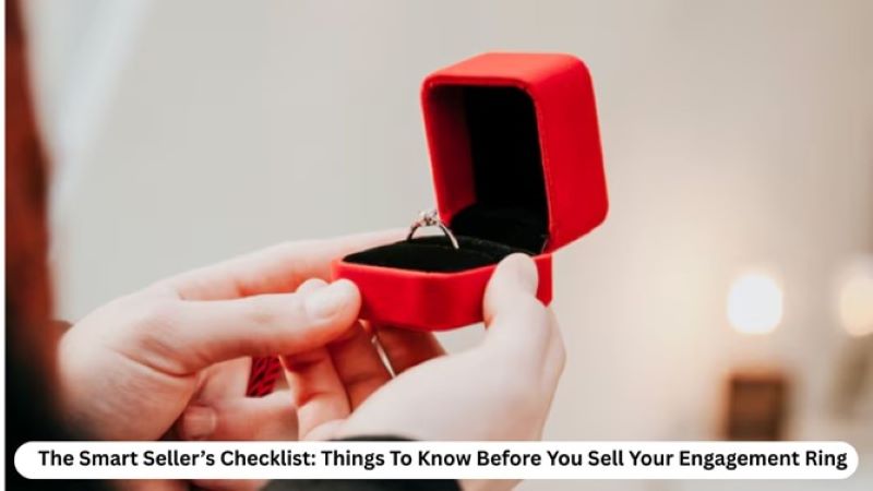 A hand holds a red ring box with an engagement ring inside, symbolizing the process of selling an engagement ring.