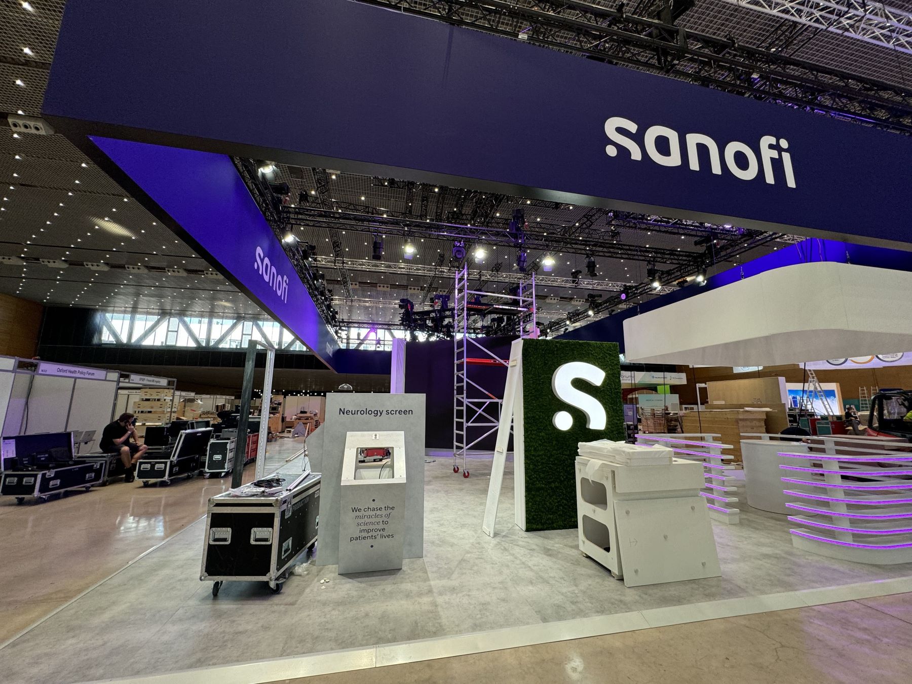 Sanofi exhibition booth featuring a neurology screen display and branding elements, set up for an event venue.