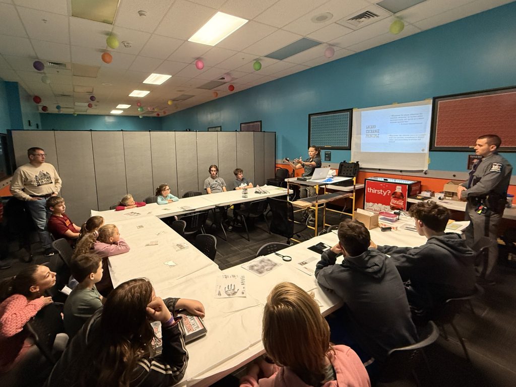 Students engaged in a science presentation at WonderWorks Destiny, with instructors discussing various topics.