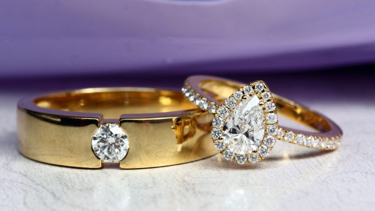 Gold engagement rings featuring a round diamond band and a pear-shaped diamond ring with smaller gems.