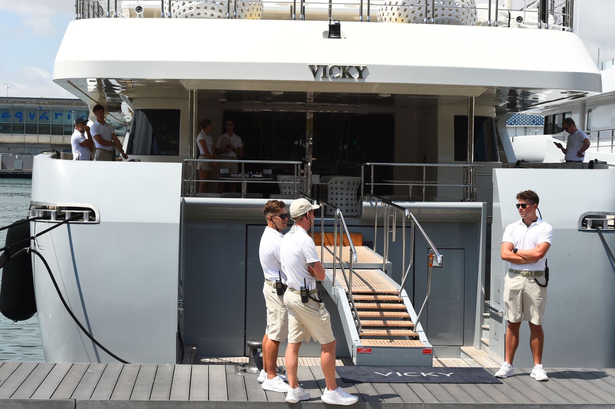 Luxury yacht named Vicky with crew members standing on the deck and boarding area.