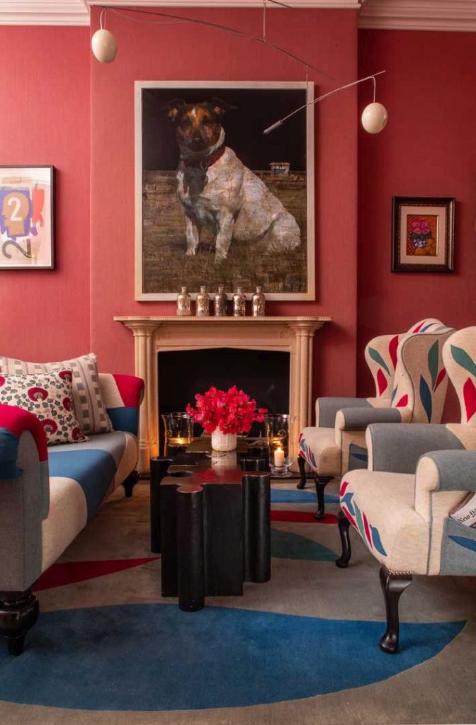 Stylish drawing room at Crosby Street Hotel with colorful furniture, a bold artwork of a dog, and a warm, inviting atmosphere.