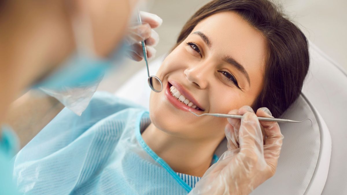 Dentist examining a patient’s teeth during a consultation before a tooth extraction in Coral Springs, FL.