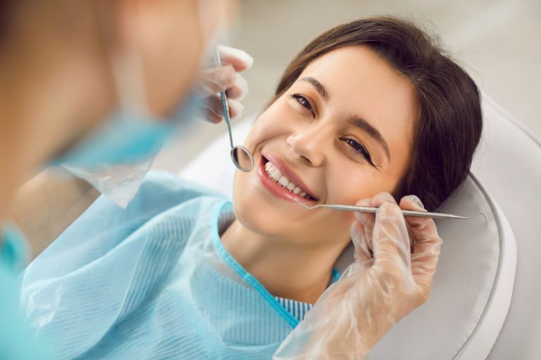 Dentist examining a patient’s teeth during a consultation before a tooth extraction in Coral Springs, FL.