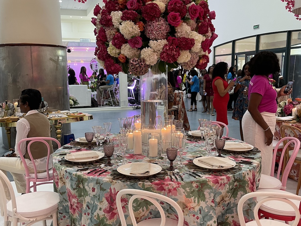 Elegant table setting adorned with flowers, candles, and fine dining ware for a Jamaican style event.