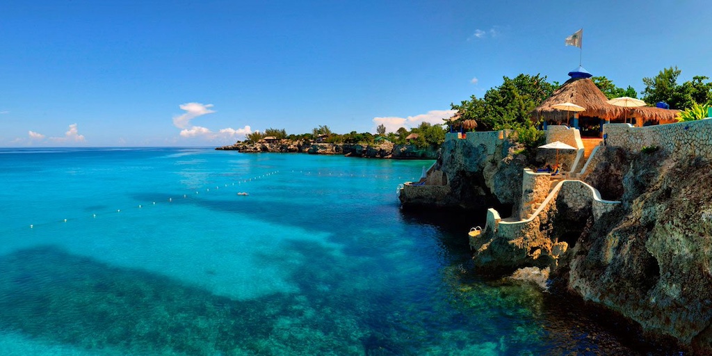 Scenic view of turquoise waters and rocky cliffs at The Caves resort in Jamaica, perfect for weddings and celebratory events.