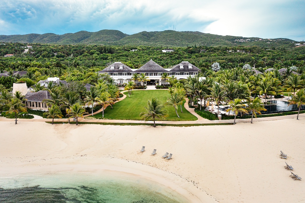 Tropical beachfront property with lush greenery and a luxurious house, perfect for weddings in Jamaica.