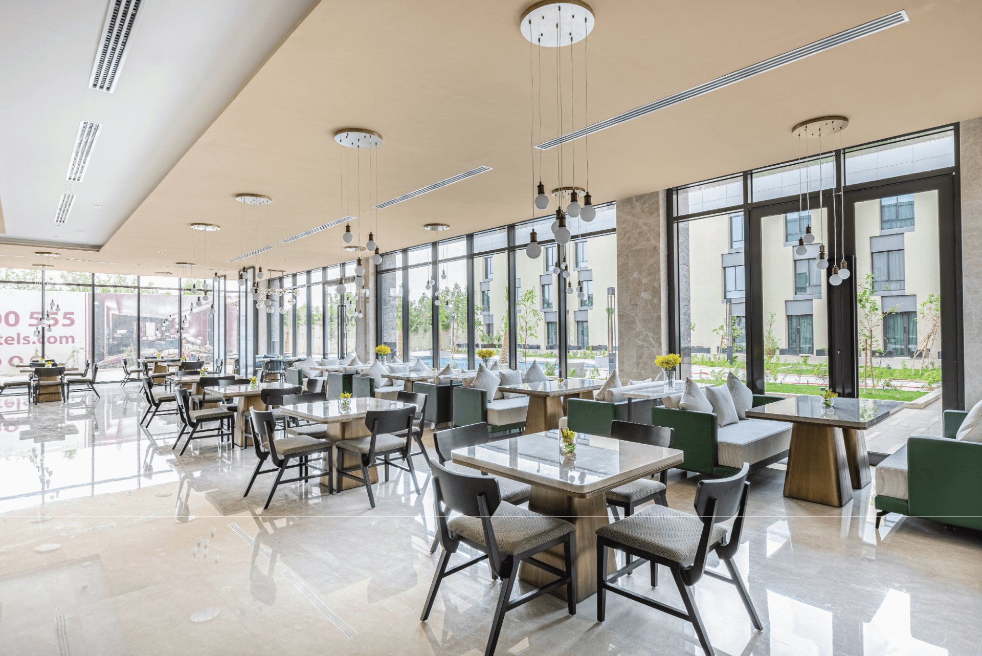 Bright and modern dining area featuring elegant tables, cozy seating, and large windows overlooking the outdoors.