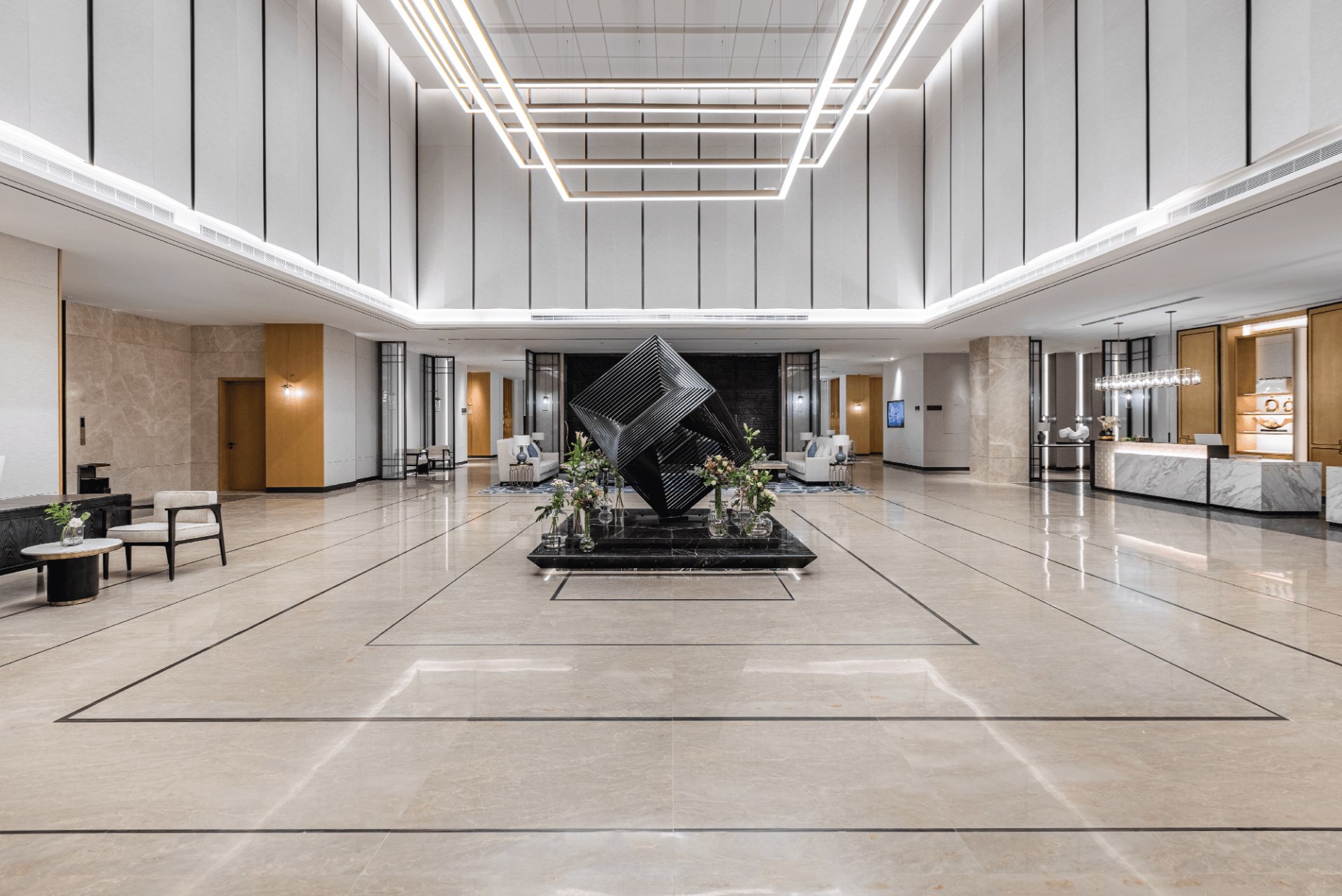 Elegant lobby of Braira Al-Rass featuring modern decor, a centerpiece sculpture, and sophisticated lighting.